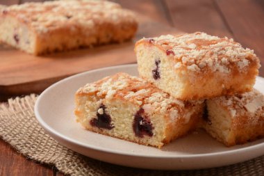 Vanilyalı ve kremalı Alman kirazlı pasta, jöleli, servis edilmiş ve dilimlenmiş.