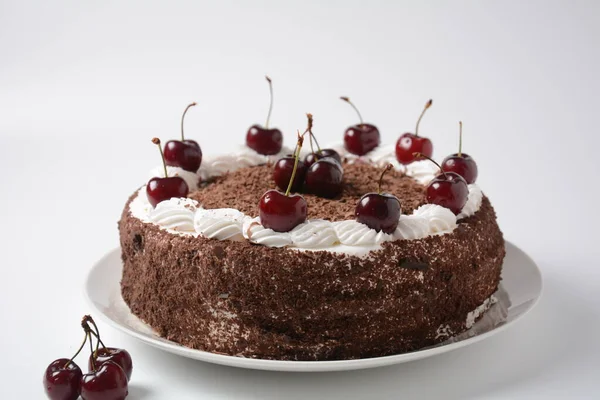 Black forest cake, Schwarzwald pie, dark chocolate and cherry dessert on a white background. Black forest cake decorated with whipped cream and cherries.