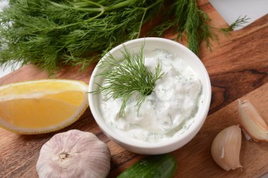 Geleneksel Yunan sosu veya salatalıklı ekşi kremalı yoğurt ve taze dereotu ile hazırlanmış Tzatziki sosu..