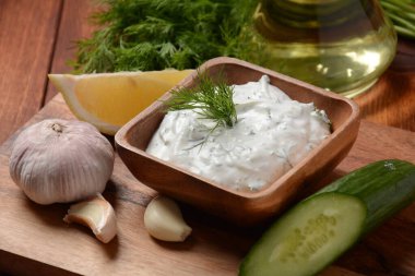 Geleneksel Yunan sosu veya salatalıklı ekşi kremalı yoğurt ve taze dereotu ile hazırlanmış Tzatziki sosu..