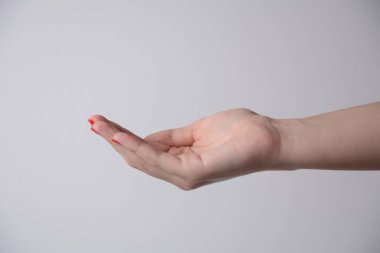 Open palm hand gesture of female hand. Isolated on white background. Outstretched female hand,  keeping empty cupped palm offering or begging concept