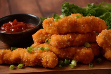 Popüler soslu tavuk göğsü külçeleri, cips ve sebzeler ahşap arka planda tercih edilir.