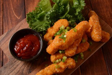 Popüler soslu tavuk göğsü külçeleri, cips ve sebzeler ahşap arka planda tercih edilir.