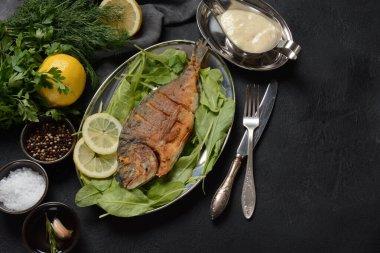Kızarmış balık dorado taze otlar ve gümüş tepside limon.