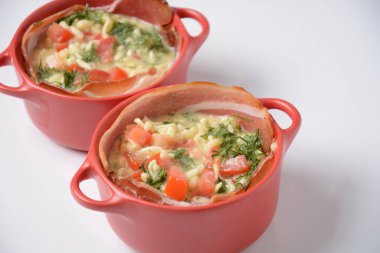 Pastırmalı omlet, rendelenmiş parmesan ve yeşillik. Çiğ yumurta sarısı ve seramik cocotte içeriği.