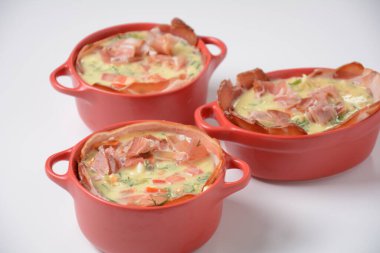 Pastırmalı omlet, rendelenmiş parmesan ve yeşillik. Çiğ yumurta sarısı ve seramik cocotte içeriği.
