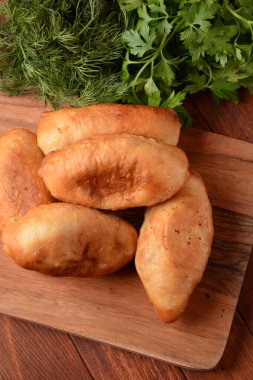 Rus börekleri (hamur işleri, sıcak kekler, pirozhki, turtalar) ahşap dolapta. Geleneksel ev yapımı patates kızartması.