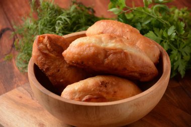 Rus börekleri (hamur işleri, sıcak kekler, pirozhki, turtalar) ahşap dolapta. Geleneksel ev yapımı patates kızartması.