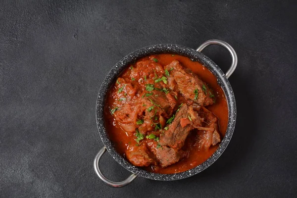 Beef meat stew. Overhead view braised beef meat stew in tomato sauce with herbs