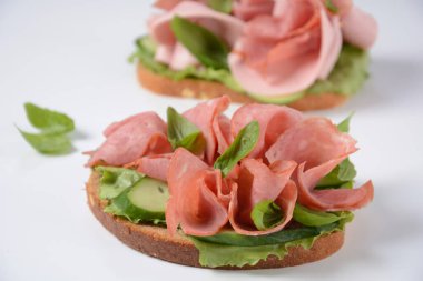 Salatalık, fesleğen ve çavdar ekmeği ve salamlı jambonlu sandviç.