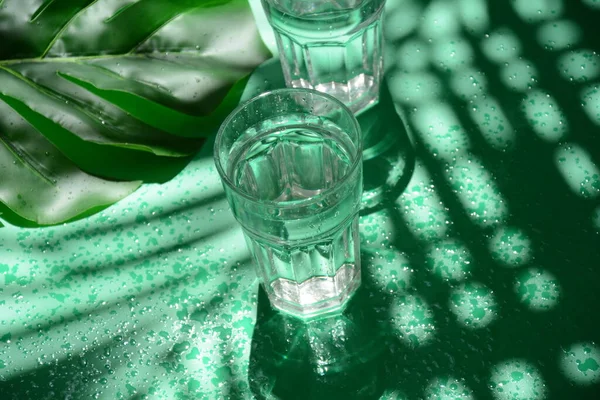 Liquido Trasparente Tazze Con Palma Tropicale Foglie Monstera Sfondo Verde — Foto Stock