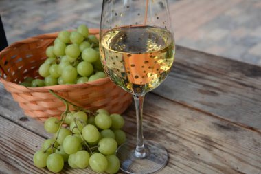 Tahta masada üzümlü bir bardak beyaz şarap. Beyaz şarap Riesling, beyaz üzümlerden.