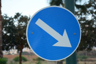 Geçiş yeri sağda. Mavi yol işareti sağ tarafı gösteren beyaz okla bu tarafta. Zorunlu işaretler. İsrail 'de yol işaretleri