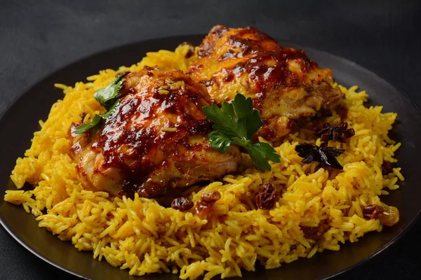 Ulusal Suudi Arabistan yemeği kızarmış tavuk kabsa ve badem, kuru üzüm, sarımsak ve biryani pilavı.