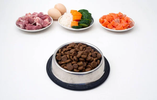 Dry pet dog food in bowl with natural ingredients. Raw meat, fish, vegetables, eggs and salad. concept of correct balanced and healthy nutrition for pet, close up