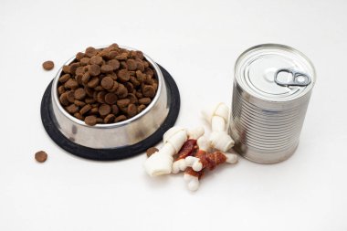 Köpek maması ve kuru yem kasede, konserve yiyecekler beyaz arka planda. Köpek maması çeşitleri..