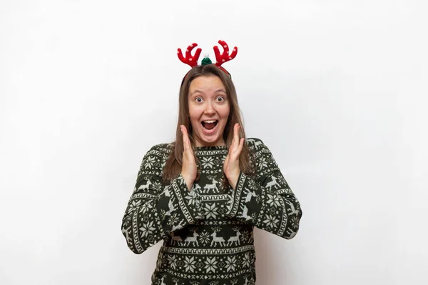스웨터를 크리스마스 머리장식을 소녀가 놀라서 손바닥을 얼굴에 진급에 — 스톡 사진