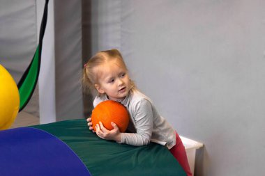 Kız, duyusal entegrasyon odasında ağır top, konsept yaratıcı duyusal oyunlar oynuyor.