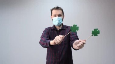 Yoncayla dans eden adam, Aziz Patrick Günü 'nün sembolü, koruyucu maskeli, pandemik bayram 2021, kutlama.