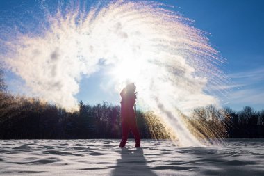 Tanınmayan biri, güneşli bir kış gününde gökyüzüne sıcak su döker. Kaynayan su sorunu, ki anında donar, sıcaklık aşırı derecede soğuk olursa kara dönüşür