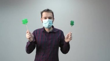 Yoncayla dans eden adam, Aziz Patrick Günü 'nün sembolü, koruyucu maskeli, pandemik bayram 2021, kutlama.