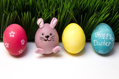 Paskalya renklerinde, yumurtalar sıralanmış, tavşanlı yumurta çimenli, mutlu Paskalyalar.