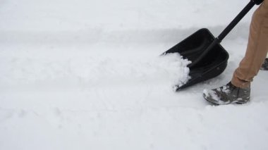 Kürekli adam karı temizler. Kar fırtınasından sonra evin yakınındaki bölgeyi temizliyorum.