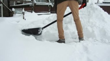 Kürekli adam karı temizler. Kar fırtınasından sonra evin yakınındaki bölgeyi temizliyorum.