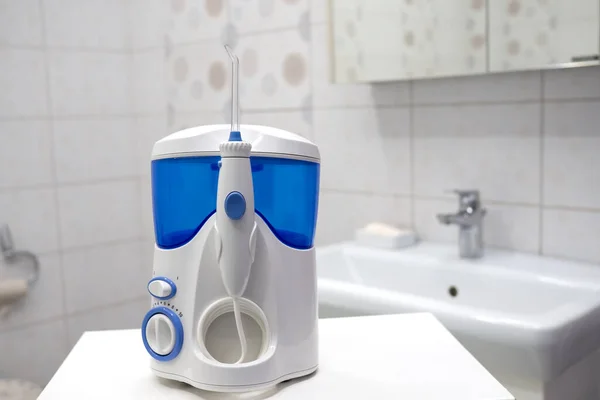Mulut gigi pembersih alat irigasi modern di kamar mandi. Kebersihan mulut, kamar mandi objek konsep — Stok Foto