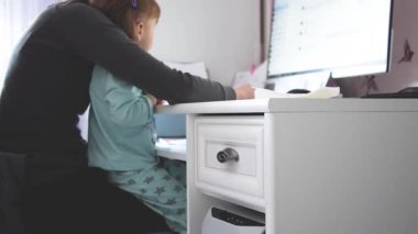 Anne çoklu görev yapıyor, kız çocuğunu kucağında tutuyor ve evde bilgisayarını seçici bir şekilde kullanıyor. Samimi, otantik ve gerçek hayatta çalışan ve ebeveynlik yapan bir anne. yavaş çekim