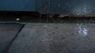 Baharda çatıdan yağmur damlaları yağar. Düşer ve yavaş çekimde sıçrar..