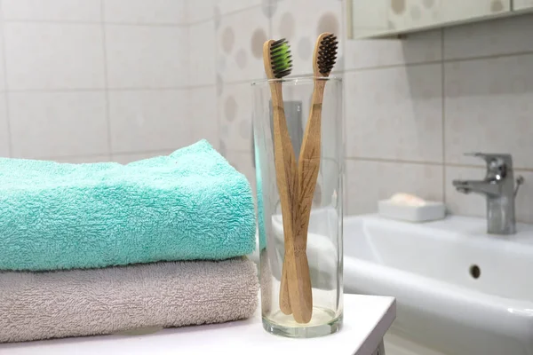 Cepillo de dientes de bambú en soporte de vidrio con toalla en el baño de basura Zero. Esenciales de belleza libre de plástico. eco amigable casa, — Foto de Stock