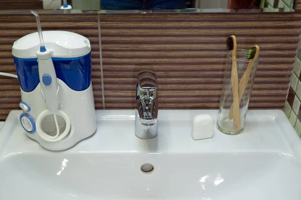 Eszközök fogmosáshoz a mosogatón. Öntözőgép és fogselyem bambusz öko fogkefével. Zéró hulladék, fenntartható fürdőszoba és életmód — Stock Fotó