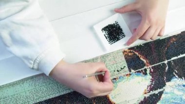 Diamond mosaic collection process top view. Woman has relaxation and rest from work in the process of monotonous activities flat lay. break for creativity and hobbies