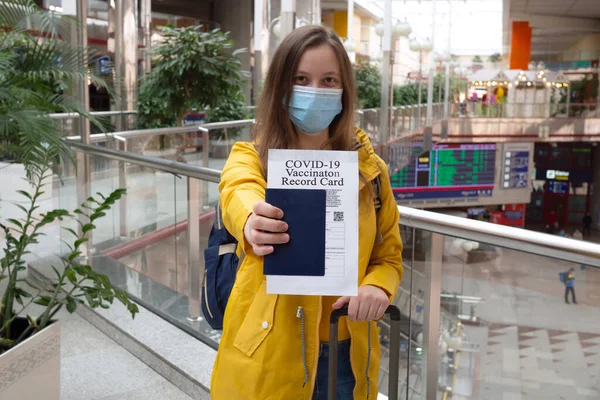 Tıbbi maskeli gezginlerin sağlık pasaportu ve aşı sertifikası var. Havaalanındaki sağlık kartında Coronavirus covid-19 aşısı yapıldı. Güvenli seyahat konsepti, gezginler için yeni normal