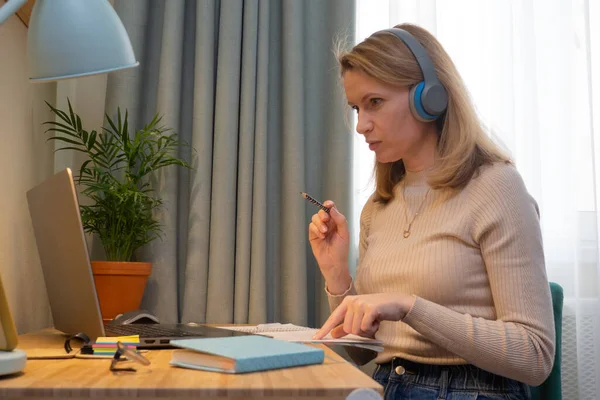 Woman in headphones online teaches a lecture for students. Distance learning online education and work