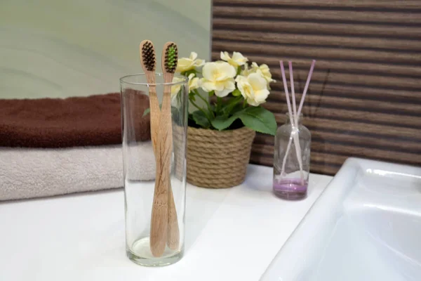Bambusz fogkefe üvegszekrényben törölközővel a zéró szemetes fürdőszobában. Műanyag szabad szépség elengedhetetlen. környezetbarát otthon, — Stock Fotó