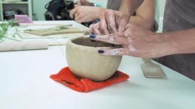 Çömlekçi kadın çömlek atölyesinde kilden kupa yapıyor. Seramik bardak oluşturma süreci. El yapımı, hobi sanatı ve el işi konsepti.