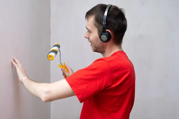 Homme Amorçant Mur Avec Rouleau Écoutant Musique Dans Casque Réparation — Photo