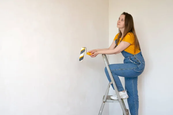 Pensive Woman Roller Ladder Looks Dreamily Room Unpainted Wall Copy — Stock Photo, Image