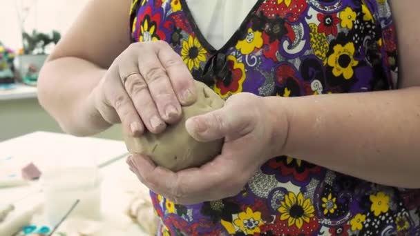 As mãos femininas estão amassando e batendo argila na oficina de cerâmica de arte, moldando a bola para fazer produtos cerâmicos. Moldagem de argila. Movimento lento — Vídeo de Stock