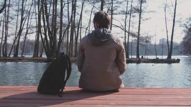 Чоловік Сидить Пірсі Біля Озера Думає Після Пішохідного Туризму Дивовижний — стокове відео