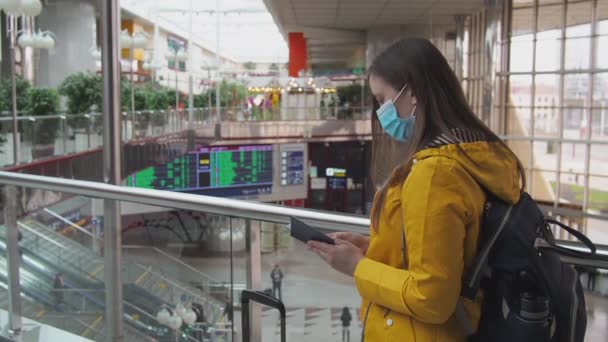 在机场或火车站 身穿黄色衣服 头戴口罩的年轻现代女游客 在大流行病和旅游期间旅行 2021年3月25日 白俄罗斯明斯克 — 图库视频影像