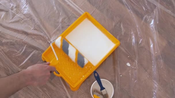 人装潢师从黄色盘子里取出带有滚筒的底漆 装修房间的修理 — 图库视频影像