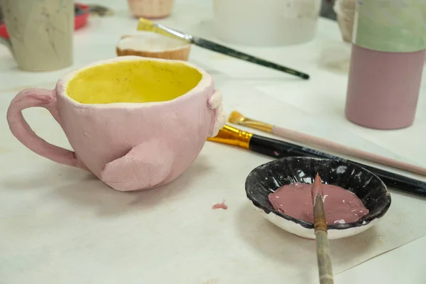 Barn flicka målning med borste på lera keramik kopp i keramik verkstad studio. Utveckling av konst och måleri hos barn — Stockfoto