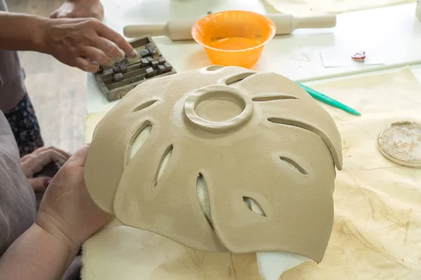 Женщина-гончар делает глиняный лист монстры в мастерской керамики. Процесс создания керамической вазы. Рукоделие, рукоделие и рукоделие — стоковое фото