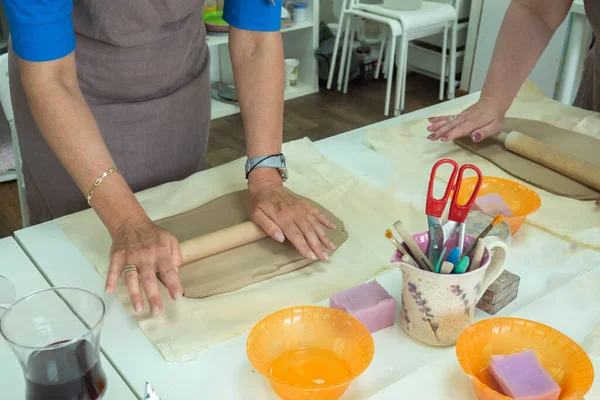 Female ceramist rolls clay using wooden rolling pin in ceramic studio. Close-up hands. Creating pottery — Stock Photo, Image