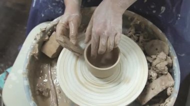 Profesyonel çömlekçi seramikçi elleri çömlekçi çarkında kil çömlek kalıbı döker. Geleneksel çömlek sanatı.