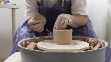 Profesyonel çömlekçi seramikçi elleri çömlekçi çarkında kil çömlek kalıbı döker. Geleneksel çömlek sanatı.