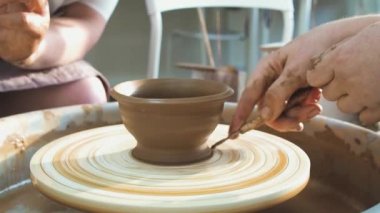 Profesyonel çömlekçi seramikçi elleri çömlekçi çarkında kil çömlek kalıbı döker. Geleneksel çömlek sanatı.